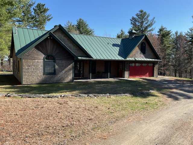 view of front of house featuring dirt driveway, metal roof, and a standing seam roof