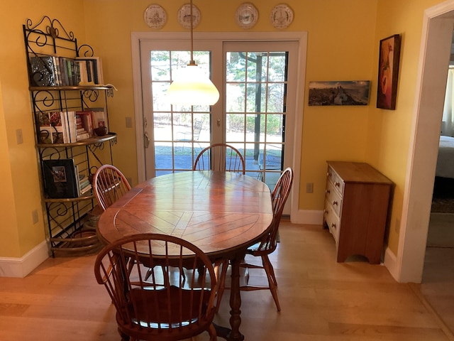 dining room featuring baseboards and light wood-style flooring