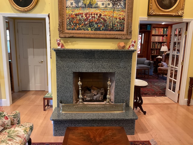 interior details with a fireplace with flush hearth and wood finished floors