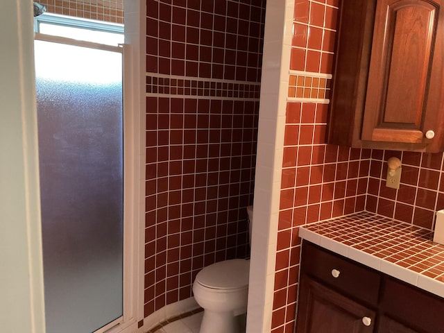 bathroom featuring backsplash, tile walls, a shower, tile patterned floors, and toilet