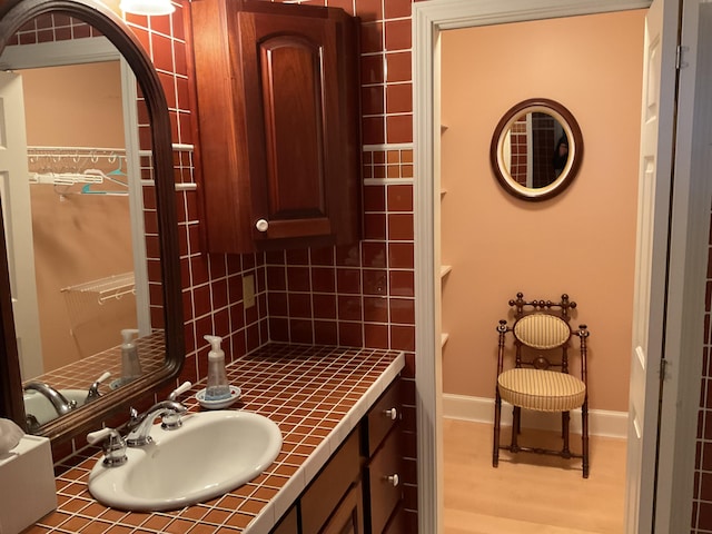 bathroom with baseboards, vanity, and wood finished floors