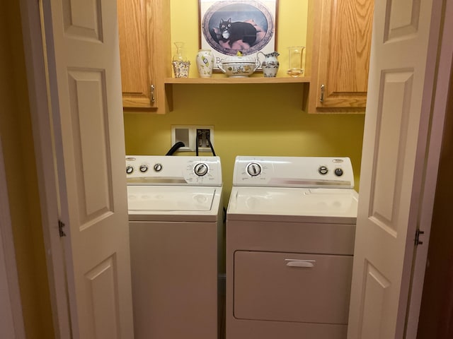 washroom with cabinet space and washing machine and dryer