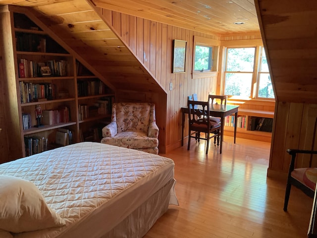 bedroom featuring wood ceiling, wood walls, and light wood-style flooring
