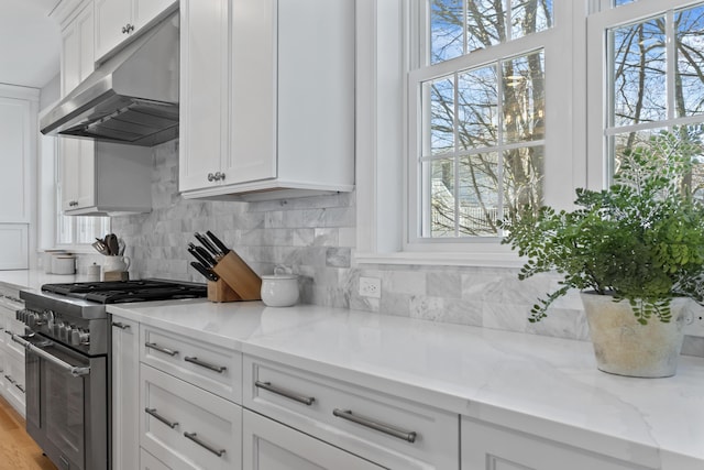 36 Fort Hill Ave, York, ME 03909 - kitchen featuring stainless steel range, backsplash, under cabinet range hood, and white cabinetry