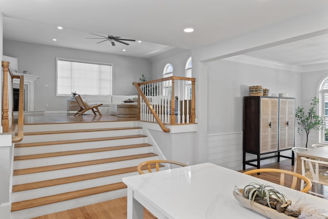 36 Fort Hill Ave, York, ME 03909 - stairway with crown molding, a glass covered fireplace, a ceiling fan, recessed lighting, and wood finished floors