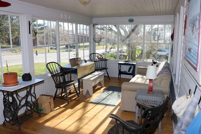 sunroom with wood finished floors and a deck
