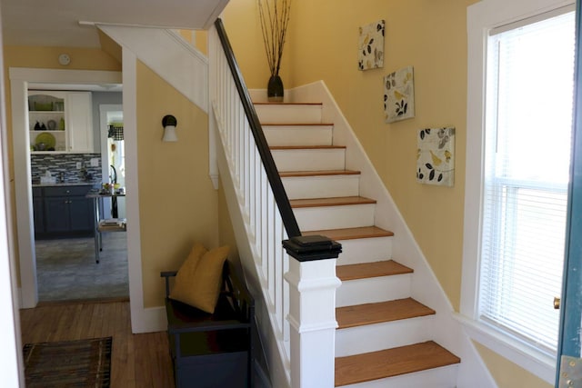 stairway featuring plenty of natural light and wood finished floors