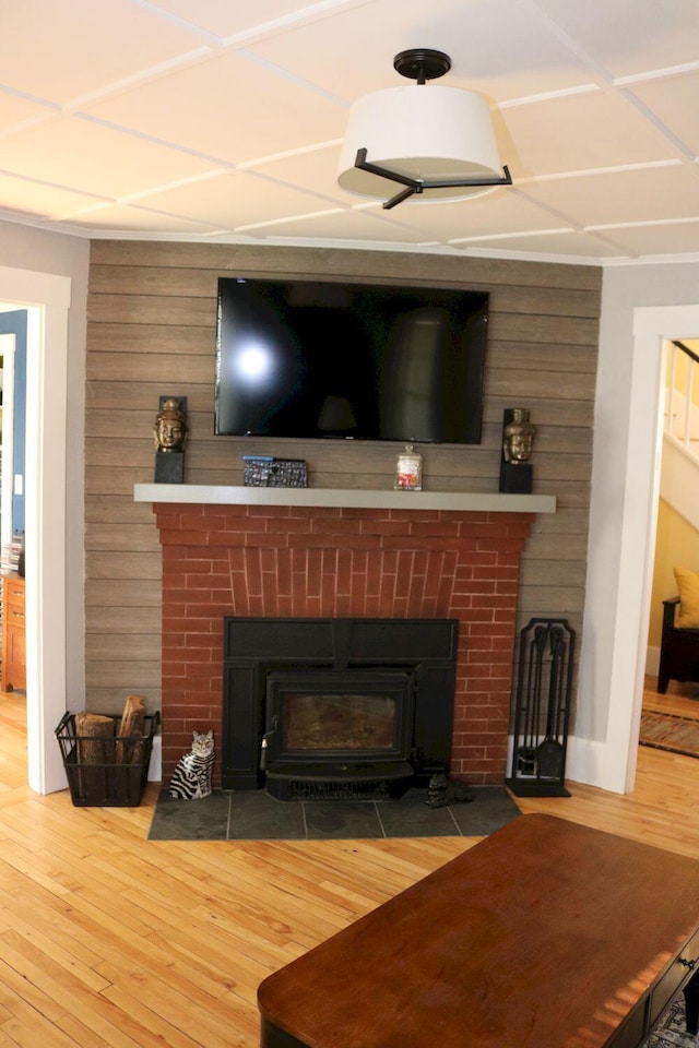 room details featuring a brick fireplace, wood walls, and wood finished floors