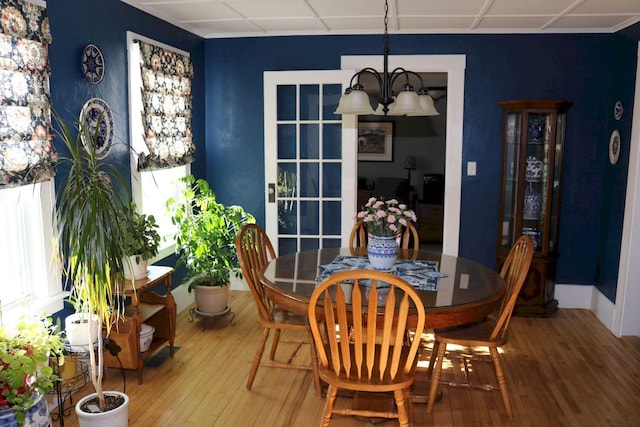 dining room featuring a healthy amount of sunlight, hardwood / wood-style flooring, and a chandelier