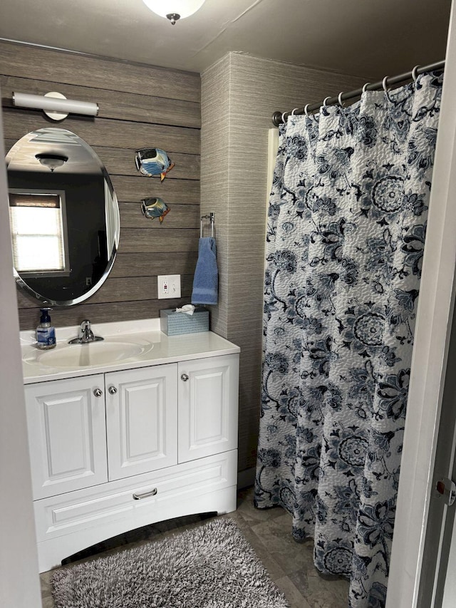 full bathroom with vanity, wood walls, and curtained shower