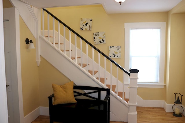 stairway with baseboards and wood finished floors