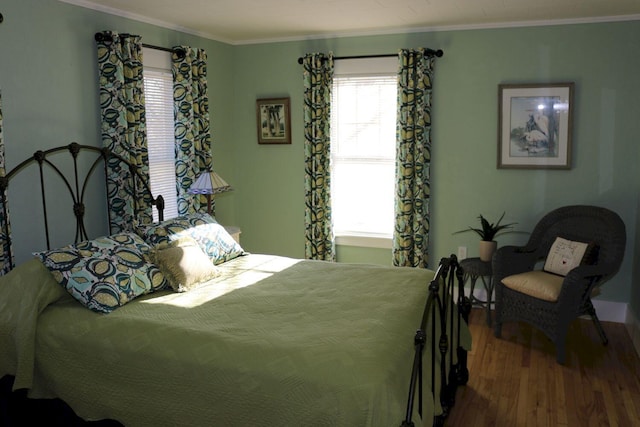 bedroom featuring crown molding, multiple windows, and wood finished floors