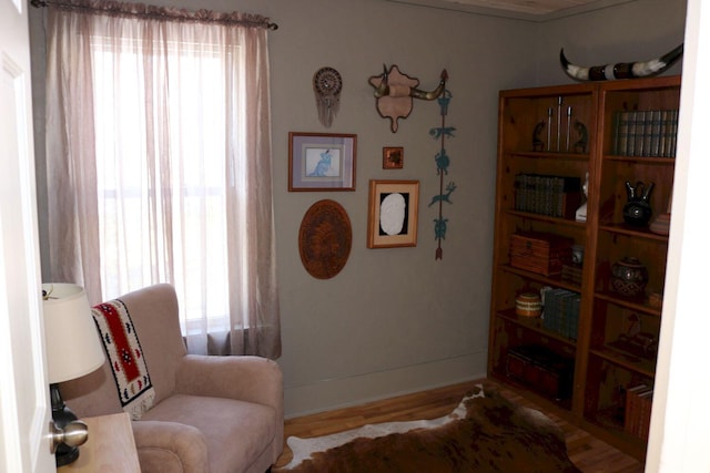 sitting room with baseboards and wood finished floors