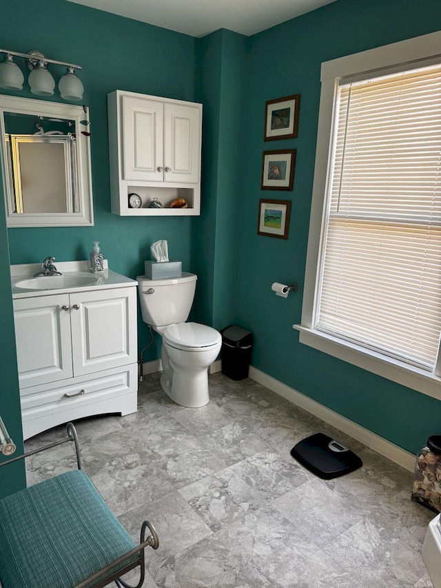 bathroom featuring an enclosed shower, baseboards, vanity, and toilet