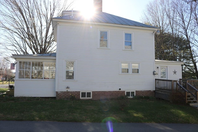 back of house with a lawn and a sunroom