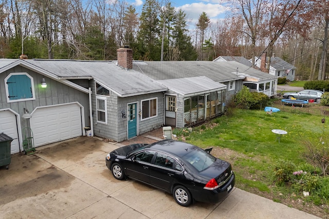 224 Branch Rd, Wells, ME 04090 - view of front facade featuring a shingled roof, a chimney, concrete driveway, a front yard, and a garage
