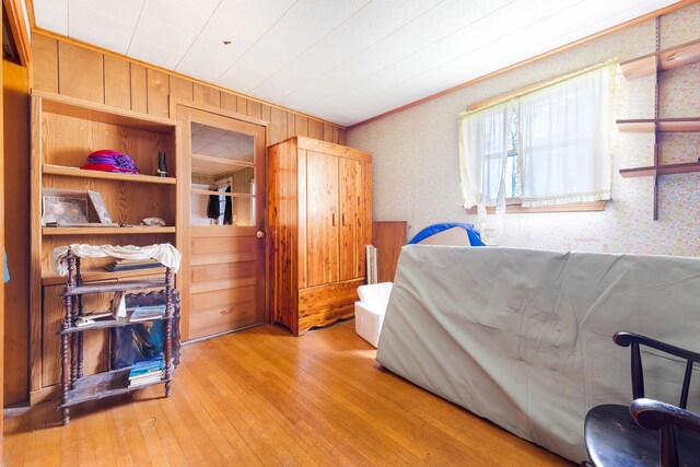 224 Branch Rd, Wells, ME 04090 - bedroom with wallpapered walls, crown molding, wood-type flooring, and wooden walls