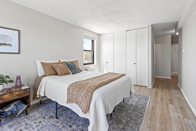 45 Eastern Promenade Unit 1E, Portland, ME 04101 - bedroom with baseboards, light wood-style flooring, and multiple closets