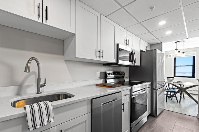 45 Eastern Promenade Unit 1E, Portland, ME 04101 - kitchen with appliances with stainless steel finishes, light stone countertops, a sink, recessed lighting, and white cabinetry