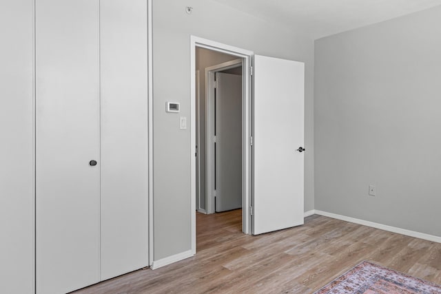 45 Eastern Promenade Unit 1E, Portland, ME 04101 - unfurnished bedroom with baseboards, a closet, and light wood finished floors