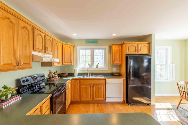 kitchen featuring a sink, black appliances, recessed lighting, under cabinet range hood, and light wood finished floors