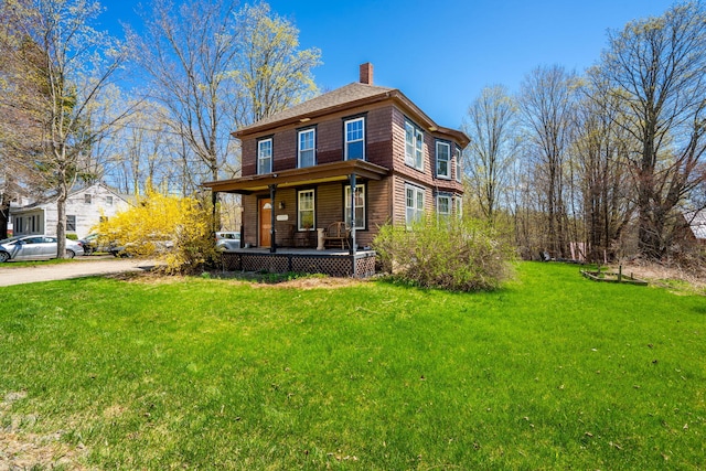 view of front of house featuring covered porch, a chimney, and a front lawn