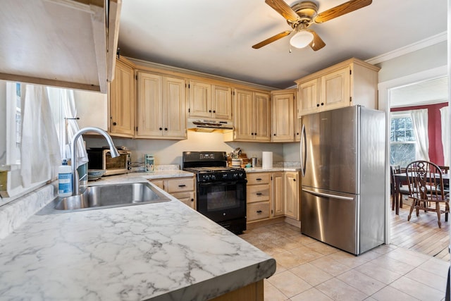 kitchen with ceiling fan, black gas range oven, a sink, freestanding refrigerator, and under cabinet range hood