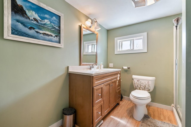 bathroom featuring visible vents, vanity, wood finished floors, toilet, and baseboards