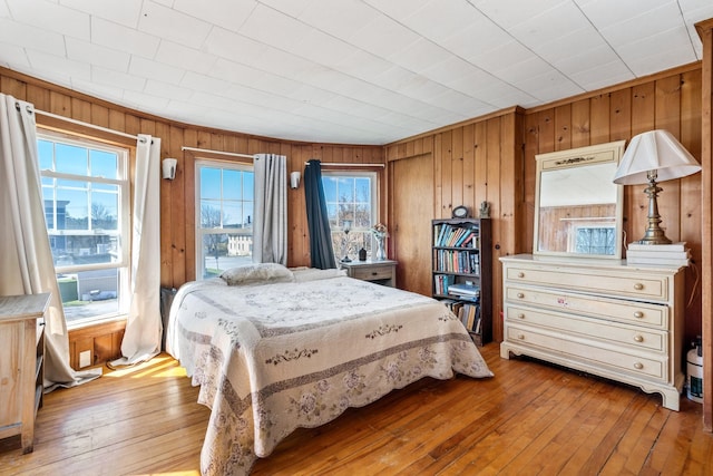 bedroom featuring wooden walls and hardwood / wood-style flooring