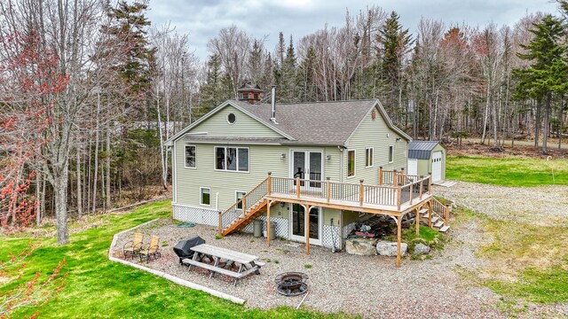 17 Kokadjo N Rd, Frenchtown Twp, ME 04441 - back of property with a fire pit, stairs, a deck, an outdoor structure, and french doors