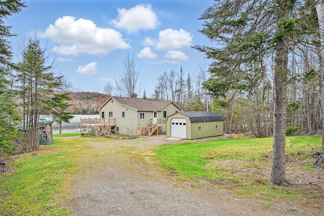 17 Kokadjo N Rd, Frenchtown Twp, ME 04441 - back of property with stairway, driveway, a wooden deck, an outbuilding, and a yard