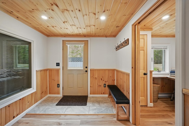 17 Kokadjo N Rd, Frenchtown Twp, ME 04441 - doorway to outside featuring a baseboard radiator, wainscoting, wooden ceiling, plenty of natural light, and wooden walls