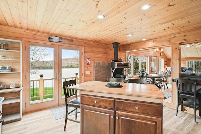 17 Kokadjo N Rd, Frenchtown Twp, ME 04441 - kitchen with a wood stove, wooden ceiling, light wood-type flooring, plenty of natural light, and a water view