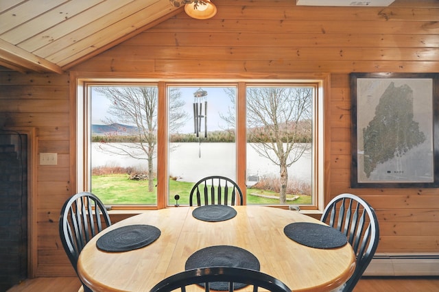 17 Kokadjo N Rd, Frenchtown Twp, ME 04441 - dining area featuring lofted ceiling, wooden walls, a baseboard radiator, a water view, and wood finished floors