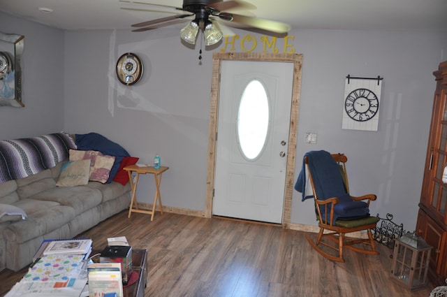 living room with baseboards, ceiling fan, and wood finished floors