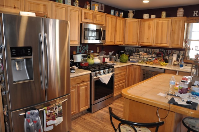 kitchen with light wood-type flooring, light countertops, recessed lighting, a sink, and stainless steel appliances