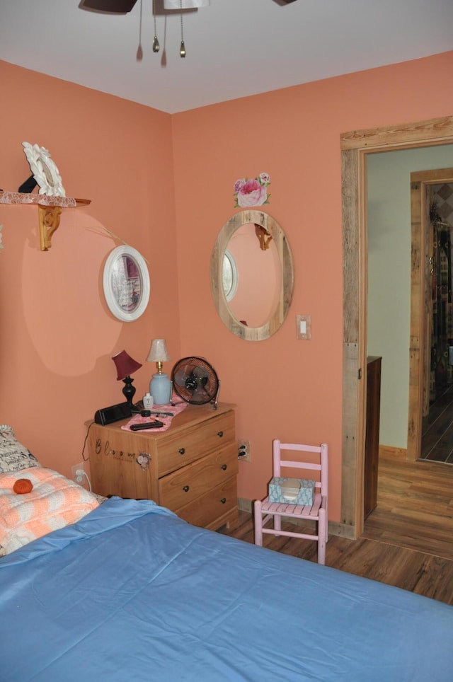 bedroom featuring baseboards, a ceiling fan, and wood finished floors