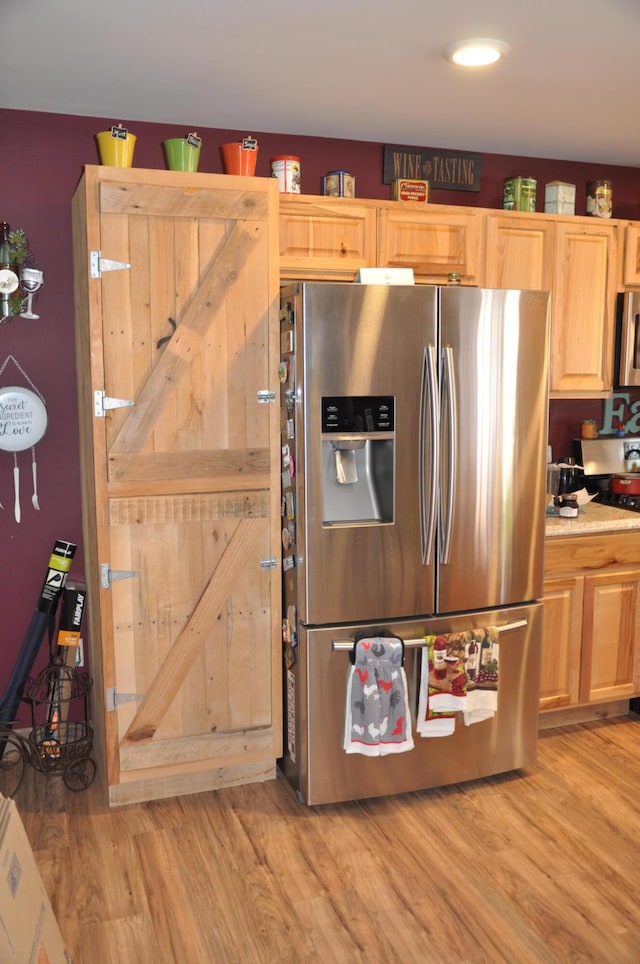 kitchen featuring light countertops, appliances with stainless steel finishes, and light wood finished floors