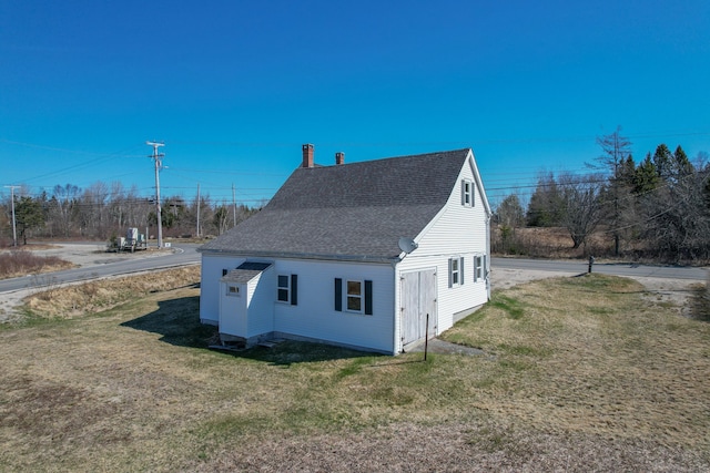 1357 Indian River Rd, Addison, ME 04606 - view of side of home with roof with shingles, a lawn, and a chimney