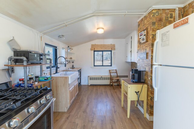 1357 Indian River Rd, Addison, ME 04606 - kitchen with freestanding refrigerator, a sink, radiator, light wood-type flooring, and vaulted ceiling