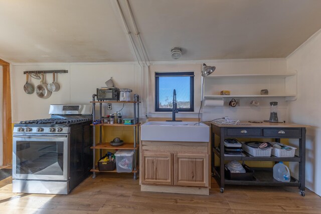 1357 Indian River Rd, Addison, ME 04606 - kitchen with stainless steel range with gas stovetop, a sink, crown molding, wood finished floors, and open shelves
