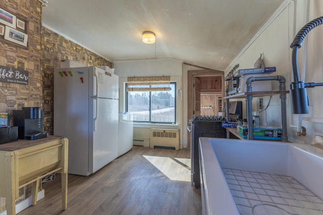 1357 Indian River Rd, Addison, ME 04606 - kitchen with freestanding refrigerator, radiator heating unit, wood finished floors, vaulted ceiling, and a baseboard heating unit