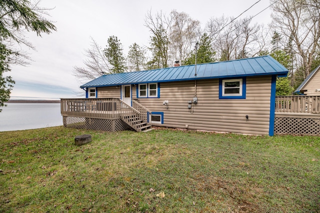 114 Smith Rd, Hudson, ME 04449 - rear view of property with a wooden deck, faux log siding, metal roof, and a lawn