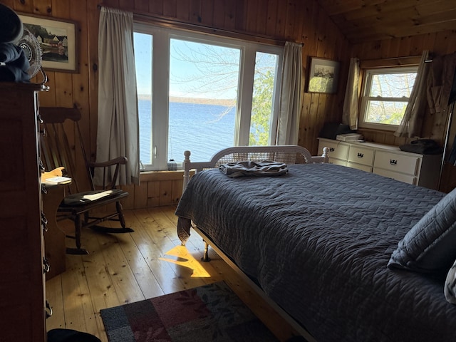 114 Smith Rd, Hudson, ME 04449 - bedroom with wood walls, lofted ceiling, light wood-style flooring, and a water view