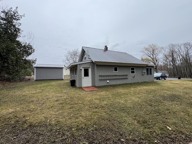 3043 W Chapman Rd, Mapleton, ME 04757 - rear view of house featuring a chimney, a yard, and metal roof