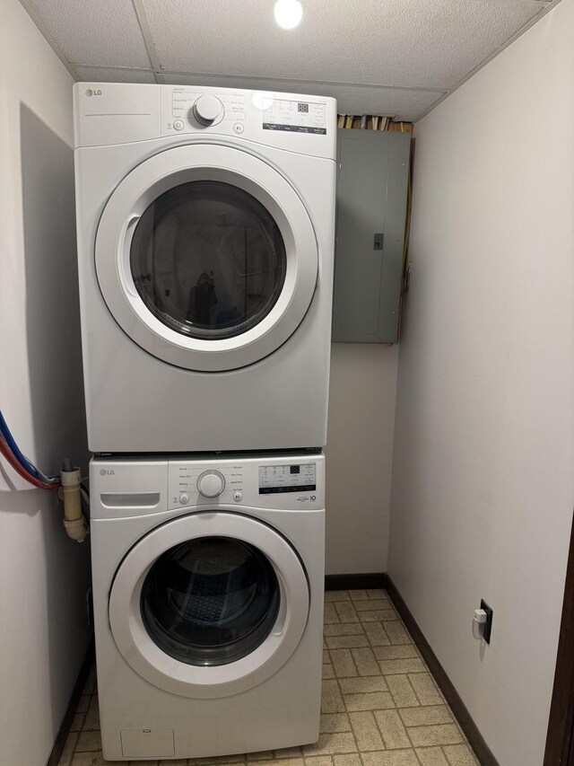 3043 W Chapman Rd, Mapleton, ME 04757 - laundry room with baseboards, electric panel, stacked washer and dryer, and laundry area