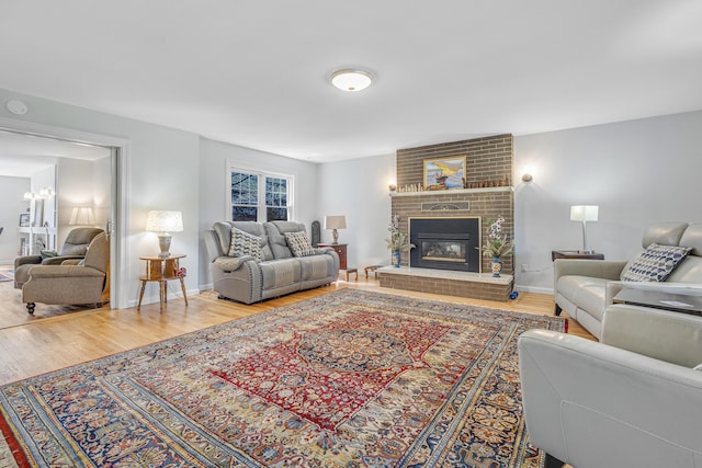 living room featuring baseboards, a fireplace, and wood finished floors