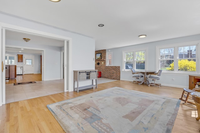 living area with light wood-type flooring and baseboards