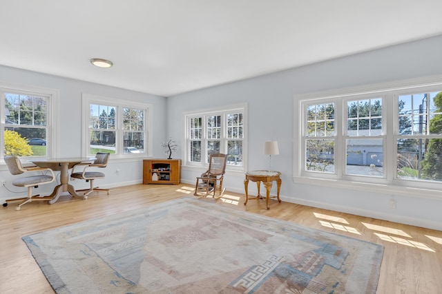 living area with baseboards and wood finished floors