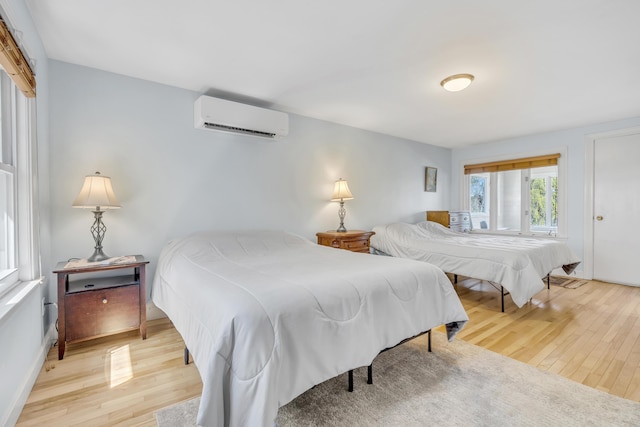 bedroom with a wall unit AC and wood finished floors